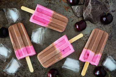 Çikolata ve vişneli dondurma. Koyu bir arkaplana dağılmış genel görünüm.