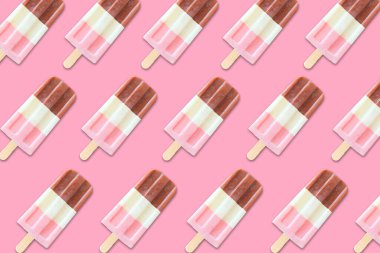 Renkli yaz buzlu şekeri deseni. Pastel pembe arka planda Napoli buzu patlar. Üst görünüm.