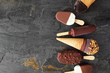 Çikolatalı dondurmalı tatlılar. Fotokopi alanı olan koyu bir arkaplan üzerindeki yan görünüm kenarlığı.