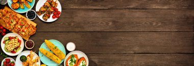 Koyu renk ahşap afiş üzerine yaz barbekü ızgara köşe sınırı. Kızarmış ekmek, tavuk ve karides şişi, doldurulmuş tatlı patates, mısır, meyve ve salata. Kopyalama alanı ile genel görünüm.