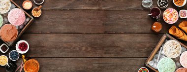 Tatlı soslu ve aromalı yaz dondurması büfesi. Koyu ahşap arka planda çift kenarlı görünüm üzerinde.