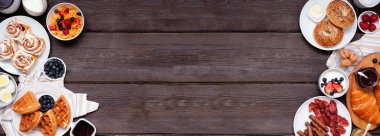 Kahvaltı ya da brunch, arka planda koyu ağaç pankartıyla çifte sınır. Genel bakış. Çeşitli tatlı ve tuzlu yiyecekler..