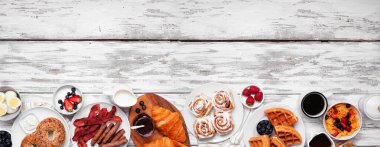 Kahvaltı ya da brunch alt sınırı. Beyaz ahşap arka planda üst manzara. Bir grup tatlı ve lezzetli yiyecek..