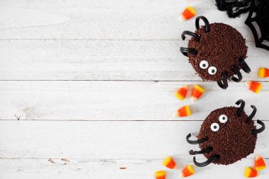 Ürkütücü Cadılar Bayramı örümcek kekleri. Beyaz ahşap zemin üzerinde kopyalama alanı olan genel görünüm.