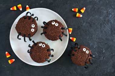 Cadılar Bayramı örümceği çörekleri, karanlık bir arkaplan üzerine en iyi manzara masası sahnesi.