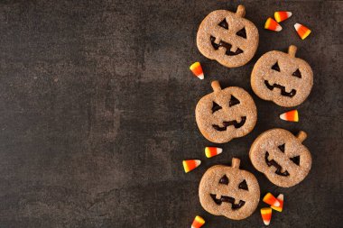 Cadılar Bayramı Jack O Lantern kurabiye kenarı sınırı. Çikolata ve balkabağı baharatı. Koyu arkaplanda üst görünüm.
