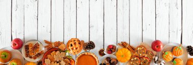 Sonbahar tatlıları alt sınırda. Bir grup tatlı sonbahar ikramının olduğu masa sahnesi. Beyaz ahşap bir arka plan üzerinde üst görünüm. Boşluğu kopyala.