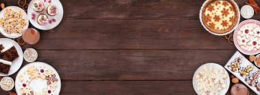 Noel kurabiyeleri ve tatlılar çift taraflı. Koyu ahşap bir arka planda tepeden aşağı manzara. Eggnog turtası, çeşitli kurabiyeler, meyveli pasta, kekler ve çikolatalı eggnog. Boşluğu kopyala.