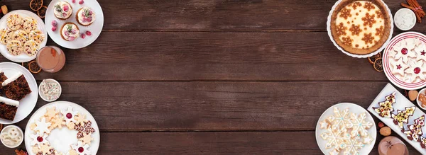 Noel kurabiyeleri ve tatlılar çift taraflı. Koyu ahşap bir arka planda tepeden aşağı manzara. Eggnog turtası, çeşitli kurabiyeler, meyveli pasta, kekler ve çikolatalı eggnog. Boşluğu kopyala.