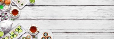 Aziz Patrick Günü çay partisi köşe başında beyaz tahta pankartın karşısında. Bir sürü yeşil yonca temalı parmak sandviçler, meyveler, çörekler ve tatlı tatlılar. Üst Manzara. Boşluğu kopyala.