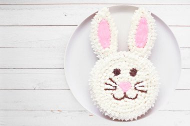 Eğlenceli Paskalya tavşanı pastası. Beyaz ahşap arka planda genel görünüm.