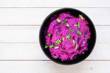 Mor tatlı patates püresi. Beyaz ahşap arka planda manzaranın üstünde. Sağlıklı ve besleyici yiyecekler..