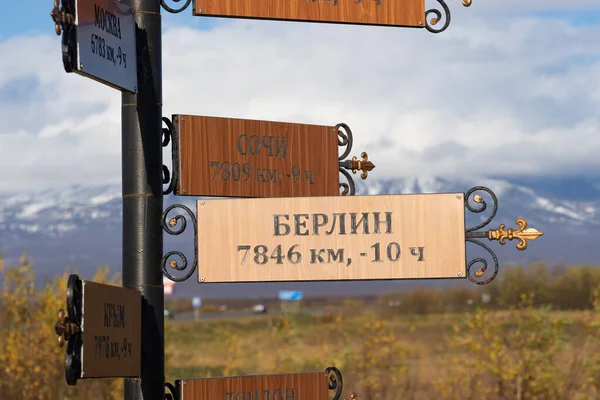 A pole with a direction indicator on the background of volcanoes in Kamchatka. Travel to Russia