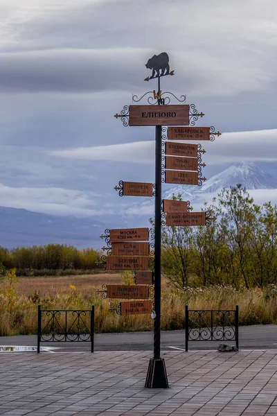 A pole with a direction indicator on the background of volcanoes in Kamchatka. Travel to Russia