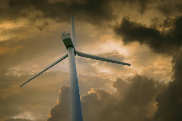 Wind power plant against a sky with white clouds