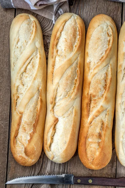 Baguetes francesas na velha mesa de madeira . — Fotografia de Stock