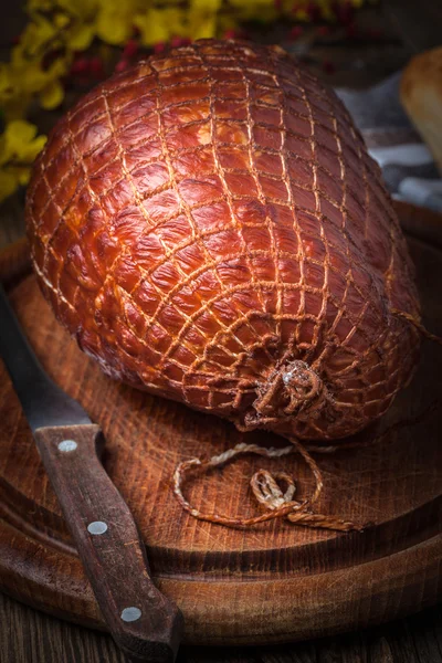 Whole ham on a wooden table. — Stock Photo, Image