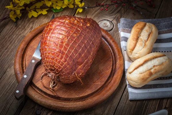 Whole ham on a wooden table. — Stock Photo, Image