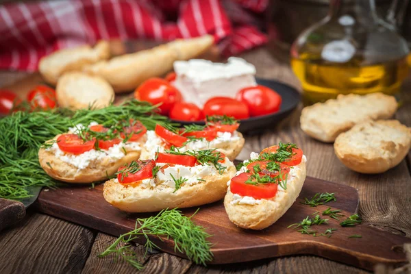 Deliciosa bruschetta con tomates, queso feta, eneldo y especias —  Fotos de Stock