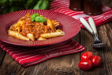 Penne bolognese beyaz plaka üzerinde.