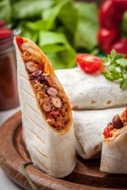 Kıyılmış et, fasulye ve sebze dolu burrito.