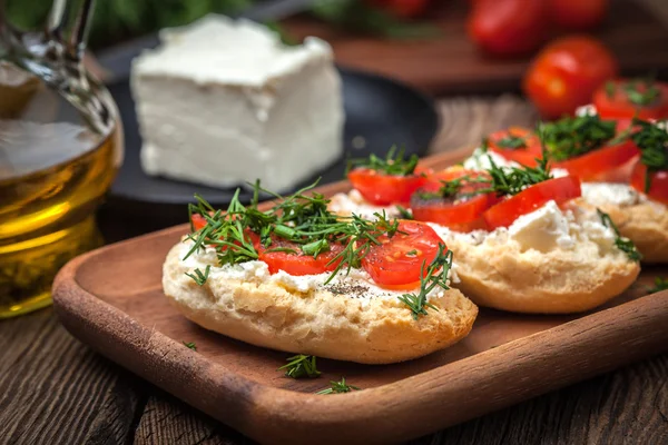 Deliciosa bruschetta con tomates, queso feta, eneldo y especias —  Fotos de Stock