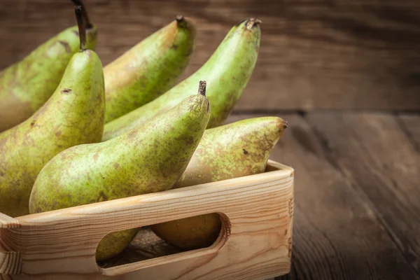 Fresh pears in a box on wooden background. — Stock Photo, Image