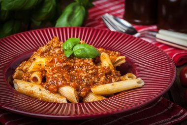 Penne bolognese beyaz plaka üzerinde.