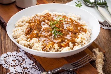 Pişmiş arpa yulaf lapası ve domuz eti güveç.