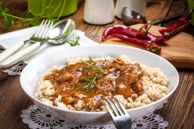 Pişmiş arpa yulaf lapası ve domuz eti güveç.