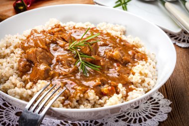 Pişmiş arpa yulaf lapası ve domuz eti güveç.