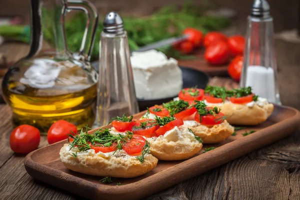 Deliciosa bruschetta con tomates, queso feta, eneldo y especias —  Fotos de Stock