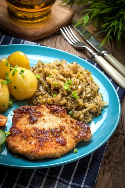 Gebakken pork chop, gebakken aardappelen en gebakken jonge kool. — Stockfoto