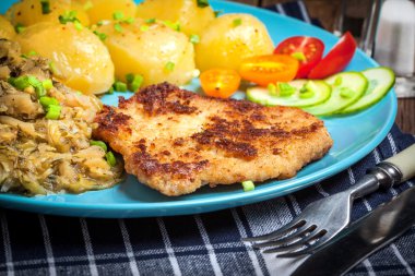 Kızarmış domuz eti, fırında patates ve kızarmış genç lahana.