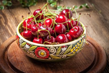 Ahşap bir masa üzerinde bir kase kiraz.