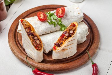 Burritos filled wiht minced meat, bean and vegetables. clipart
