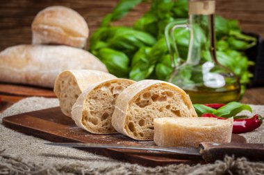 Ciabatta ekmeği kesme tahtası üzerinde dilimlenmiş.