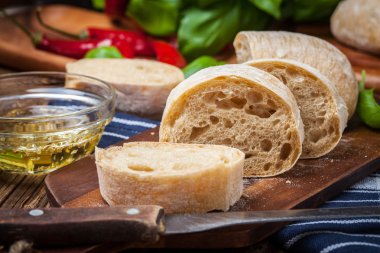 Ciabatta ekmeği kesme tahtası üzerinde dilimlenmiş.