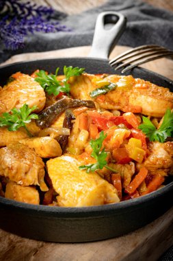 Dökme demir tavada sebzeli kızarmış tavuk..