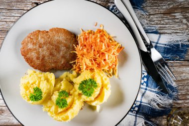 Patates püresi ve havuç salatasıyla servis edilen ev yapımı kıymalı pirzola..