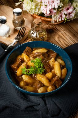 Soslu sığır eti yahnisi, patates köftesiyle servis edilir..