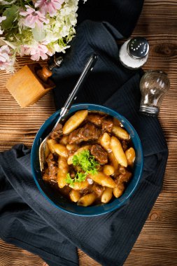 Soslu sığır eti yahnisi, patates köftesiyle servis edilir..