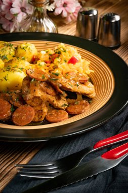 Sucuklu hindi eti, patates ve salata ile servis ediliyor..