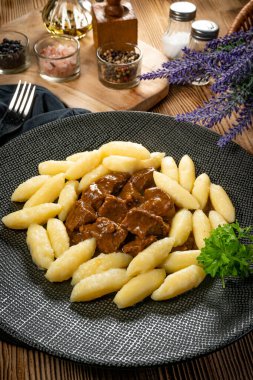 Soslu sığır eti yahnisi, patates köftesiyle servis edilir..