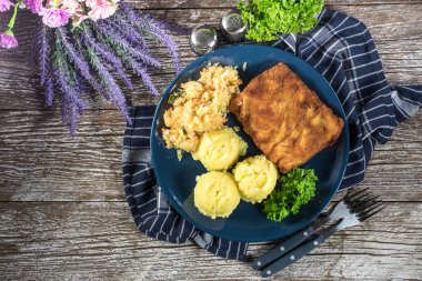 Akşam yemeğinde patates ve lahana turşusu salatası ile haşlanmış balık. Seçici odak.