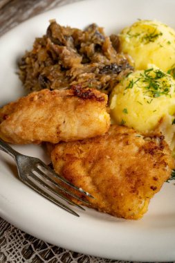 Kızarmış morina filetosu, haşlanmış patates ve mantarlı kızarmış lahana turşusu..