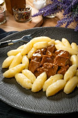 Soslu sığır eti yahnisi, patates köftesiyle servis edilir..