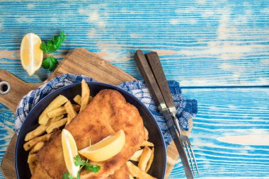 Tabakta patates kızartması olan kızarmış morina balığı. Üst görünüm.