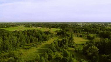 Batan güneşin ışığında çayırlar ve ormanlar. Yukarıdan görüldü..