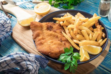 Tabağında patates kızartması olan kızarmış morina balığı..